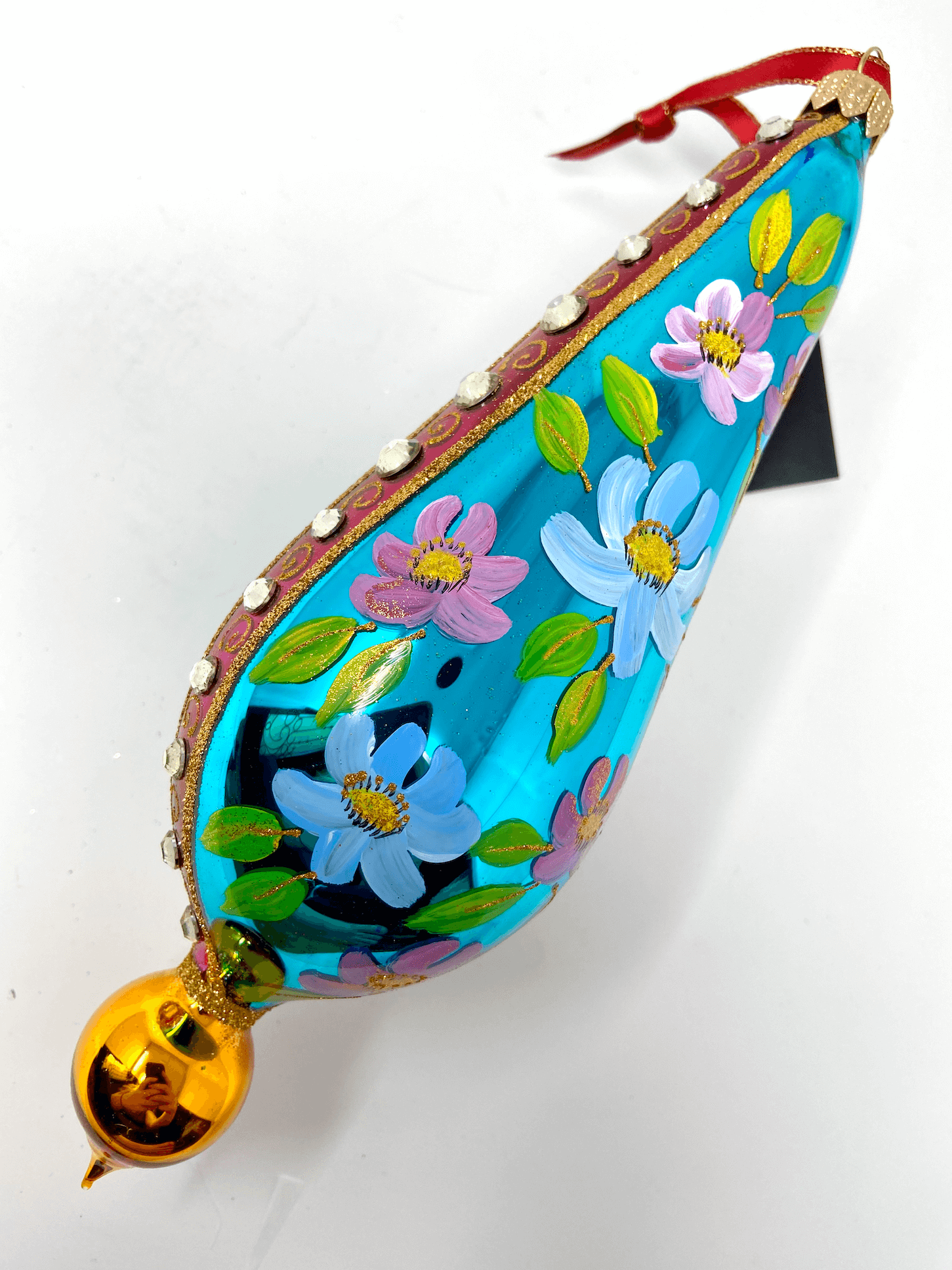 Extra large beautifully painted polish glass ornament with colorful accents. Features different colored daisies, a red stripe on an azure blue background dotted with gemstones and gold detailing.
