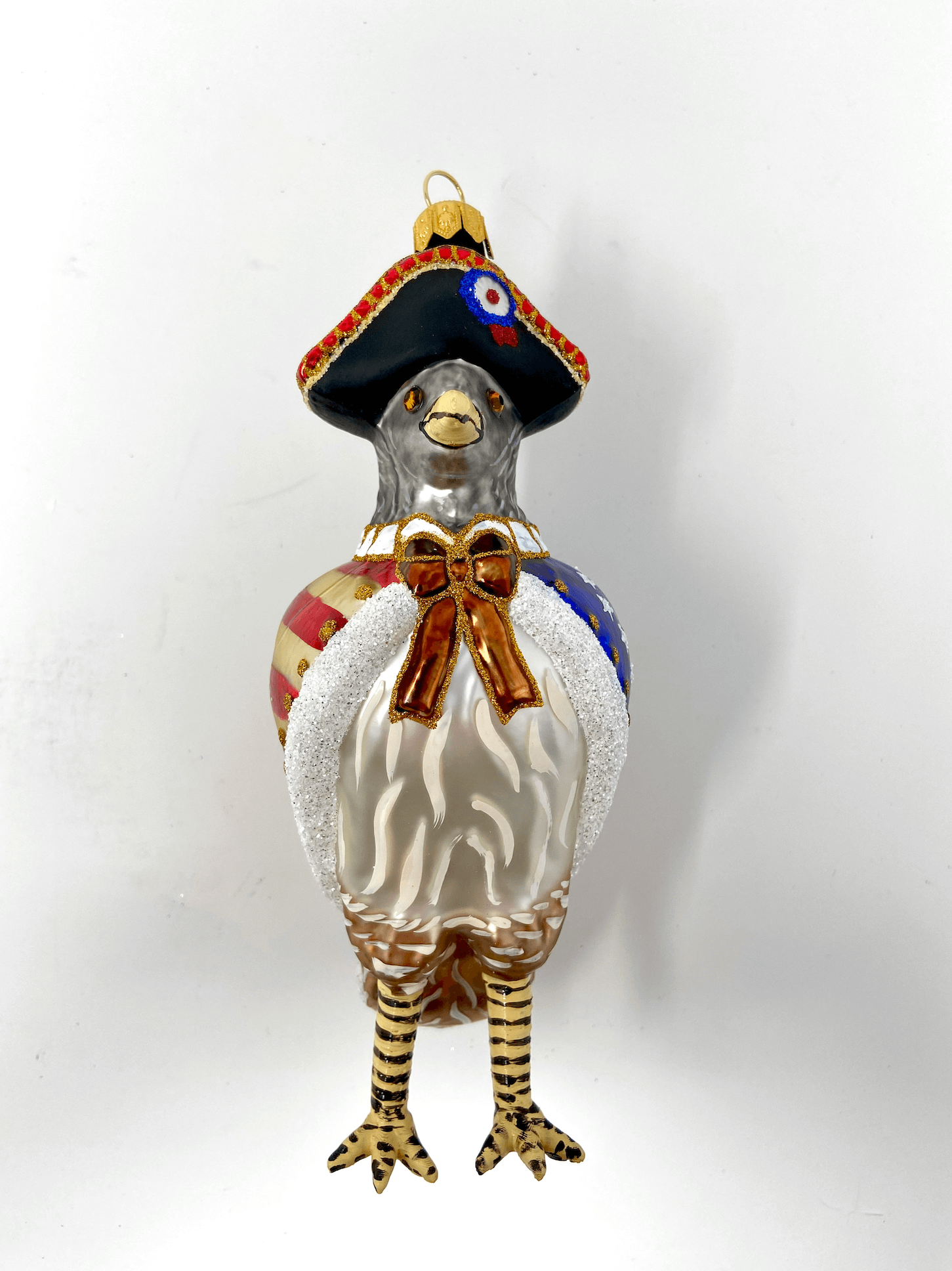 Beautiful dove bird wearing a revolutionary war cloak painted with a vintage old glory flag and minuteman militia colonial hat. Polish glass christmas ornaments in saturated colors.