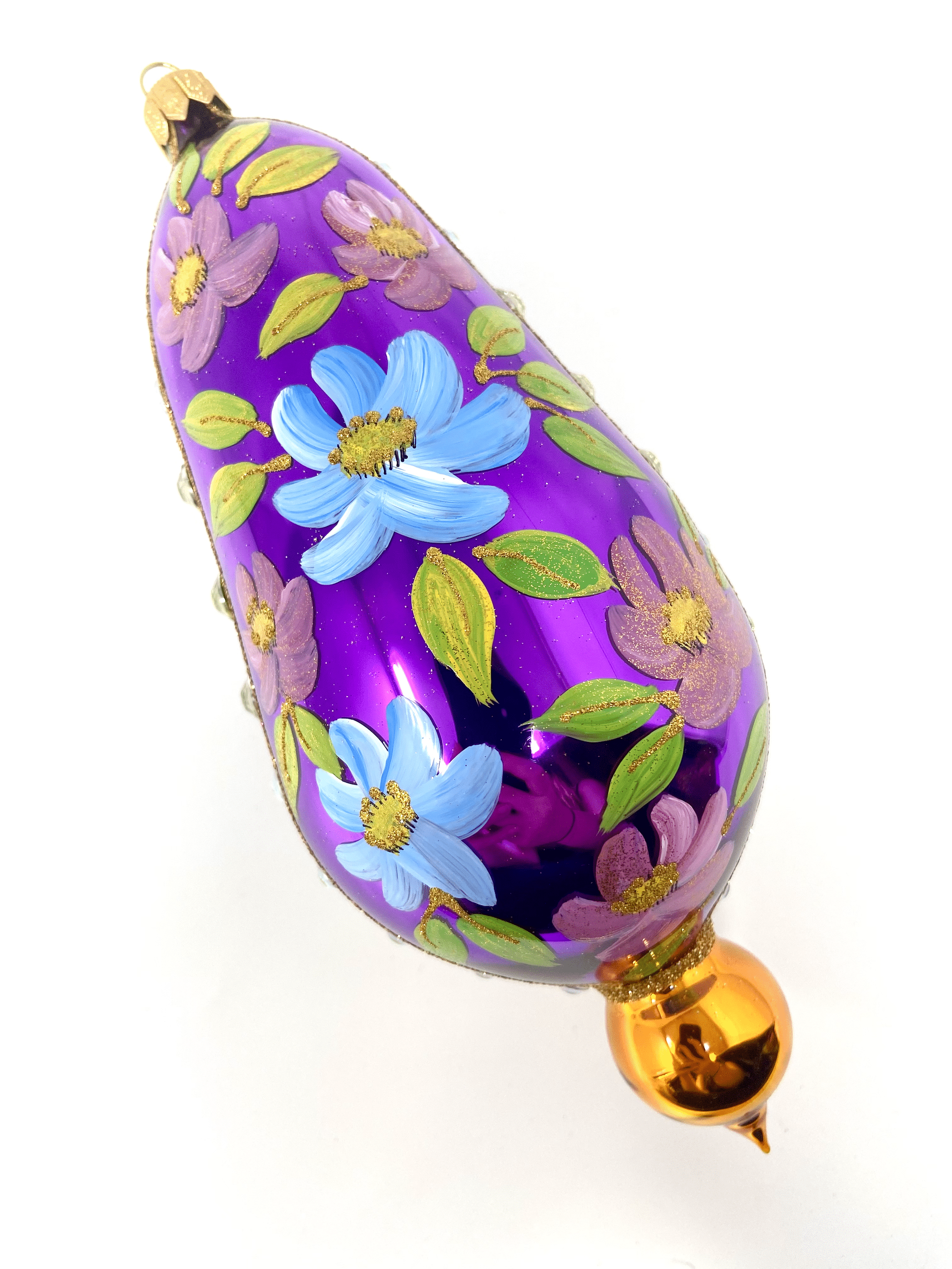 Purple eggplant shaped ornament featuring gemstones, intricate gold detailing, and hand painted floral blooms. A Christmas polish glass ornament. Floral Escape Floral Fetish.