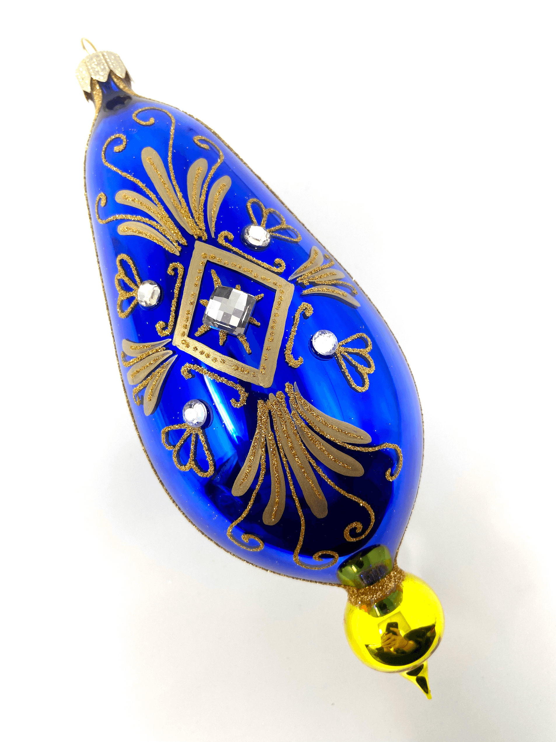 Blue eggplant shaped ornament featuring gemstones, intricate gold detailing, and hand painted floral blooms. A Christmas polish glass ornament. Floral Escape Floral Fetish.