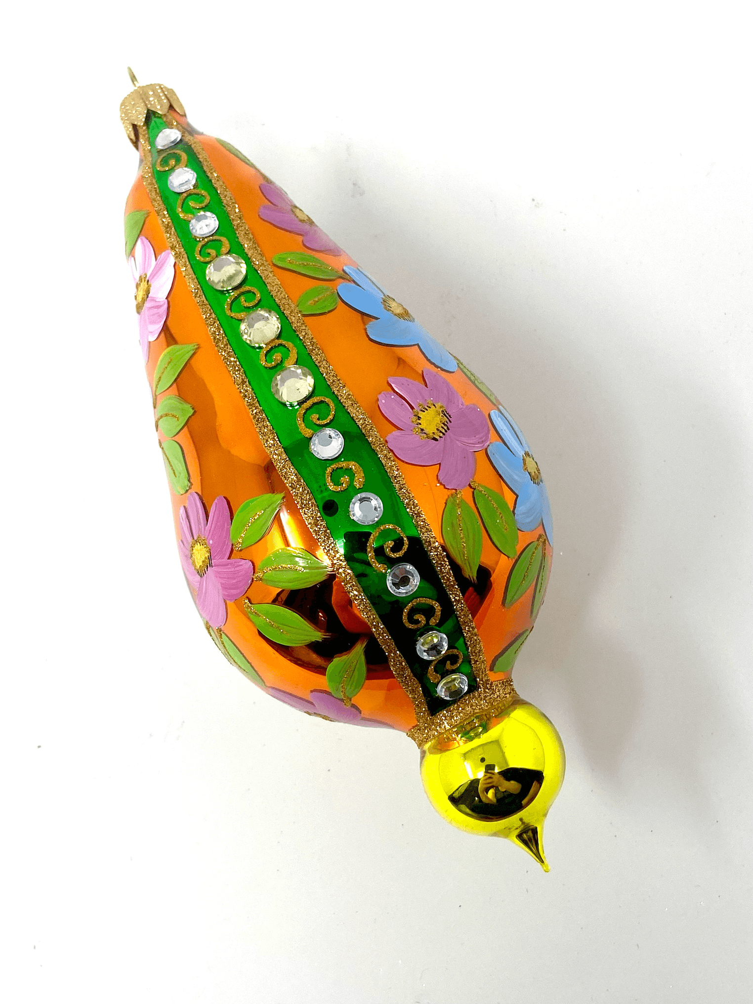 Orange eggplant shaped ornament featuring gemstones, intricate gold detailing, and hand painted floral blooms. A Christmas polish glass ornament. Floral Escape Floral Fetish.